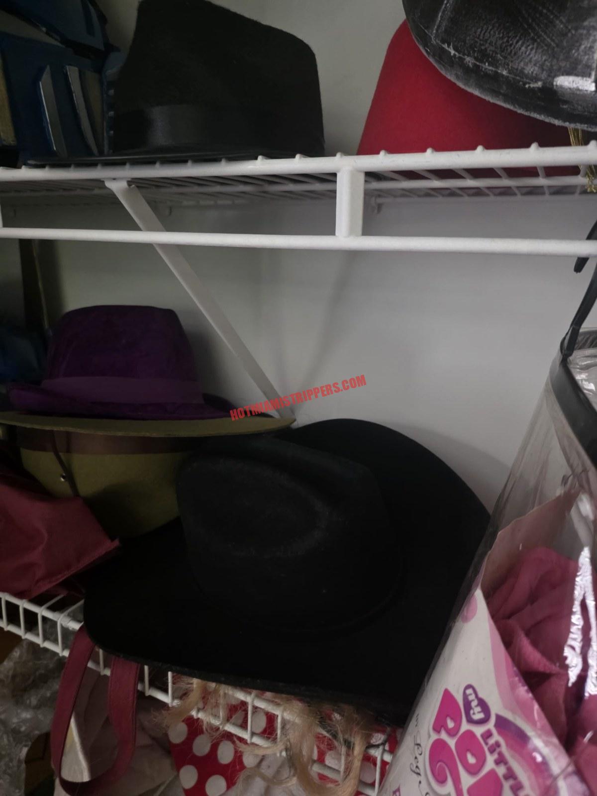 Hats stacked on a white wire shelf.