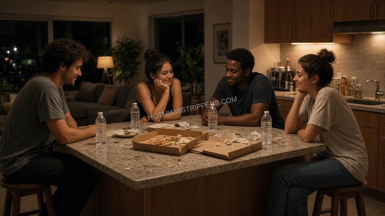 Four friends talking around a kitchen island with pizza boxes and water bottles late at night
